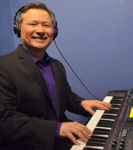 Tom Marcoux plays a keyboard in a recording studio.